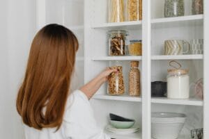 organizing-service Organizing service arranging jars on pantry shelves for organized food storage.